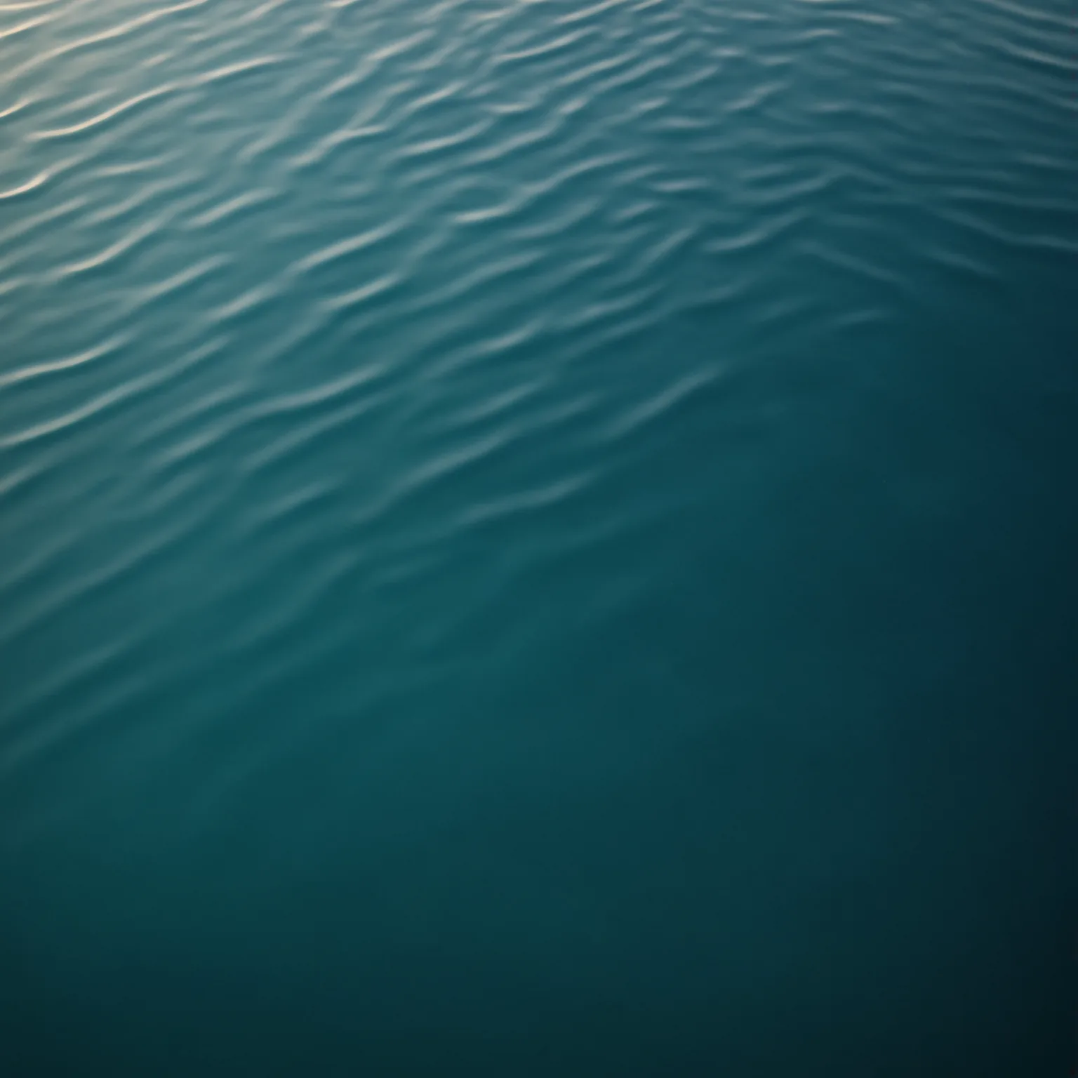 Calm lagoon water with gentle ripples, transitioning from light turquoise to deep teal.