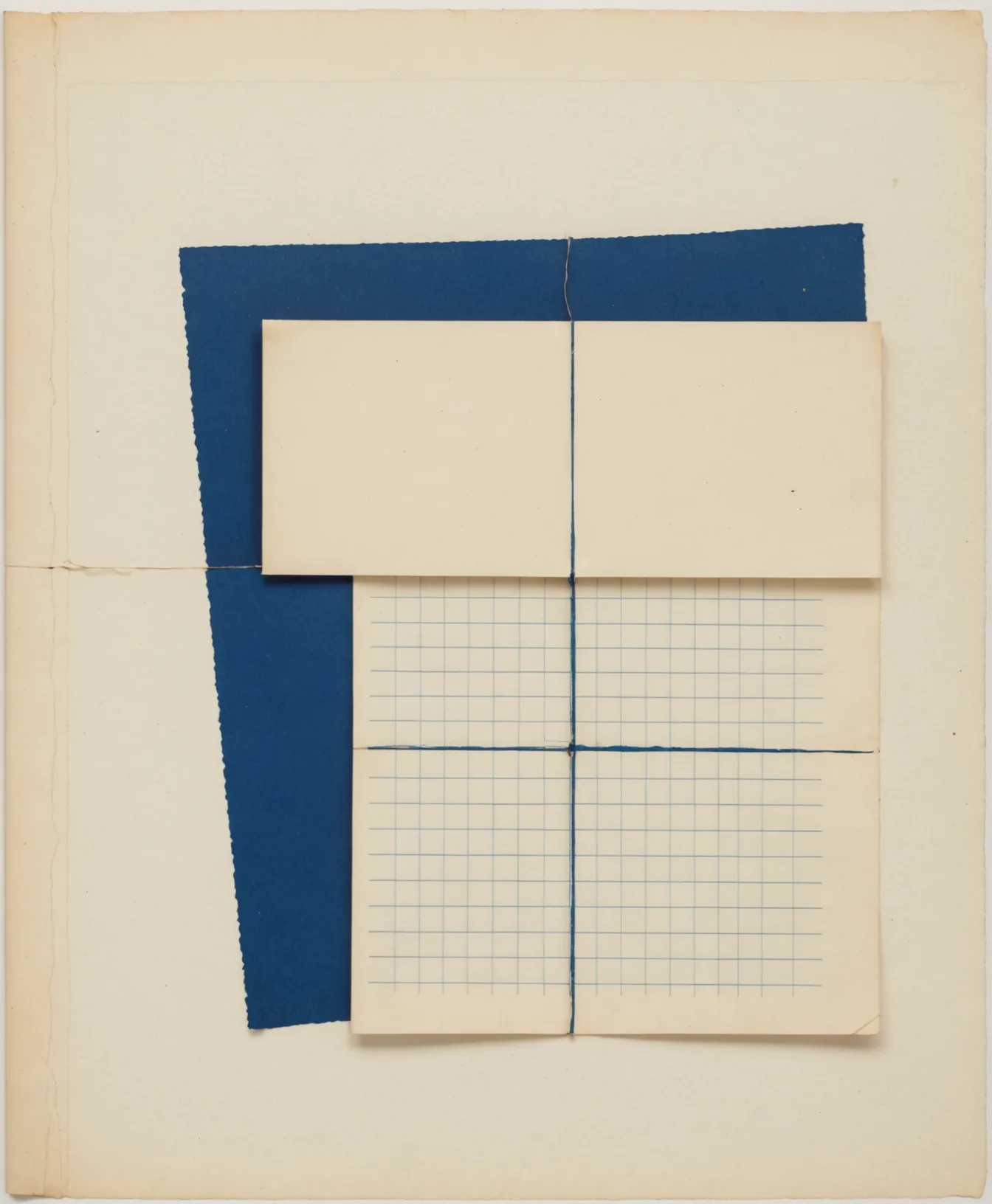 Flat-lay of navy notebook and open grid-lined ledger pages on cream background